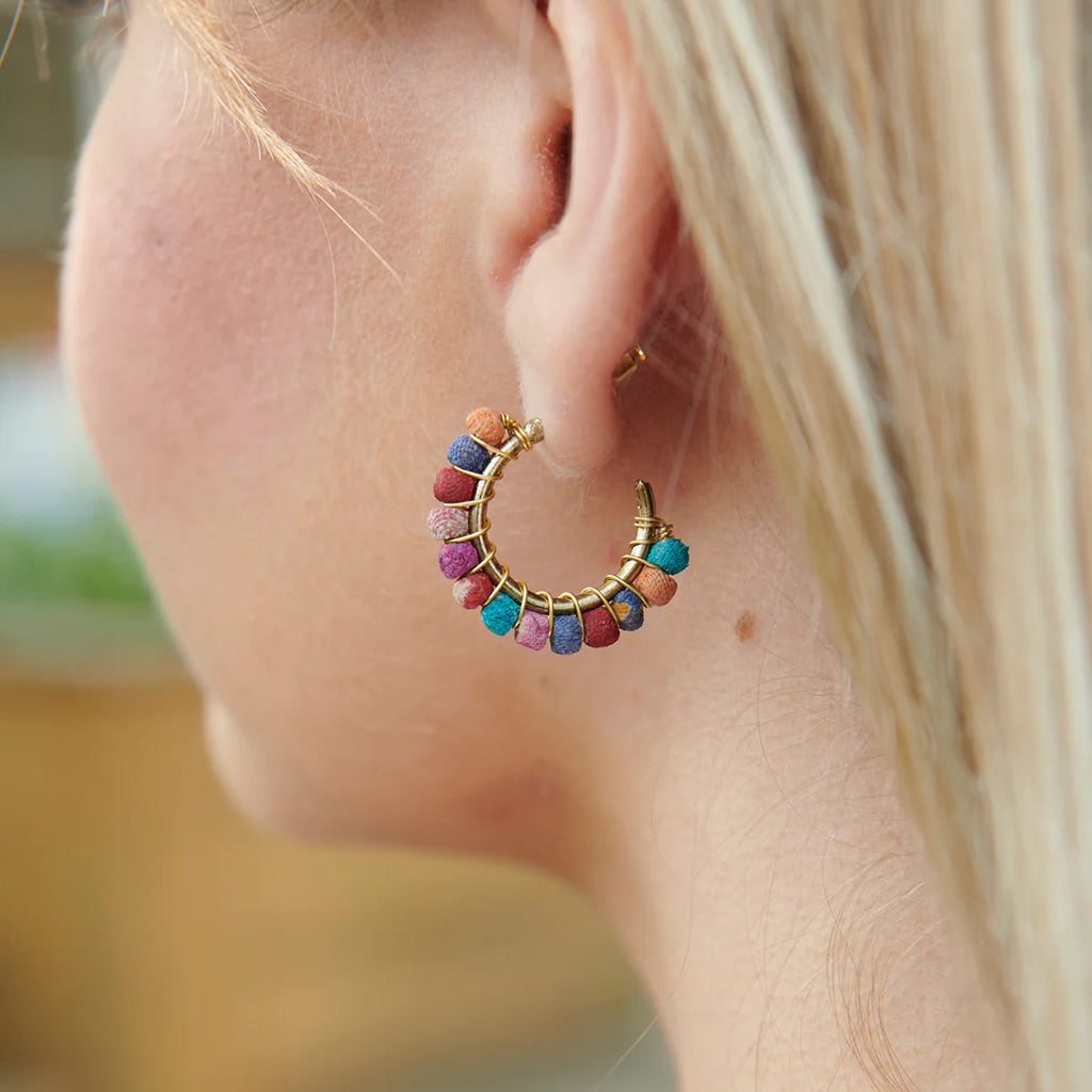 Close-up of a colorful hoop earring worn by a person.