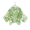 Green and white patterned kimono on a hanger against a white background
