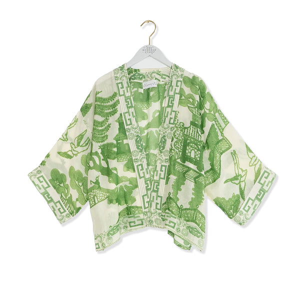 Green and white patterned kimono on a hanger against a white background
