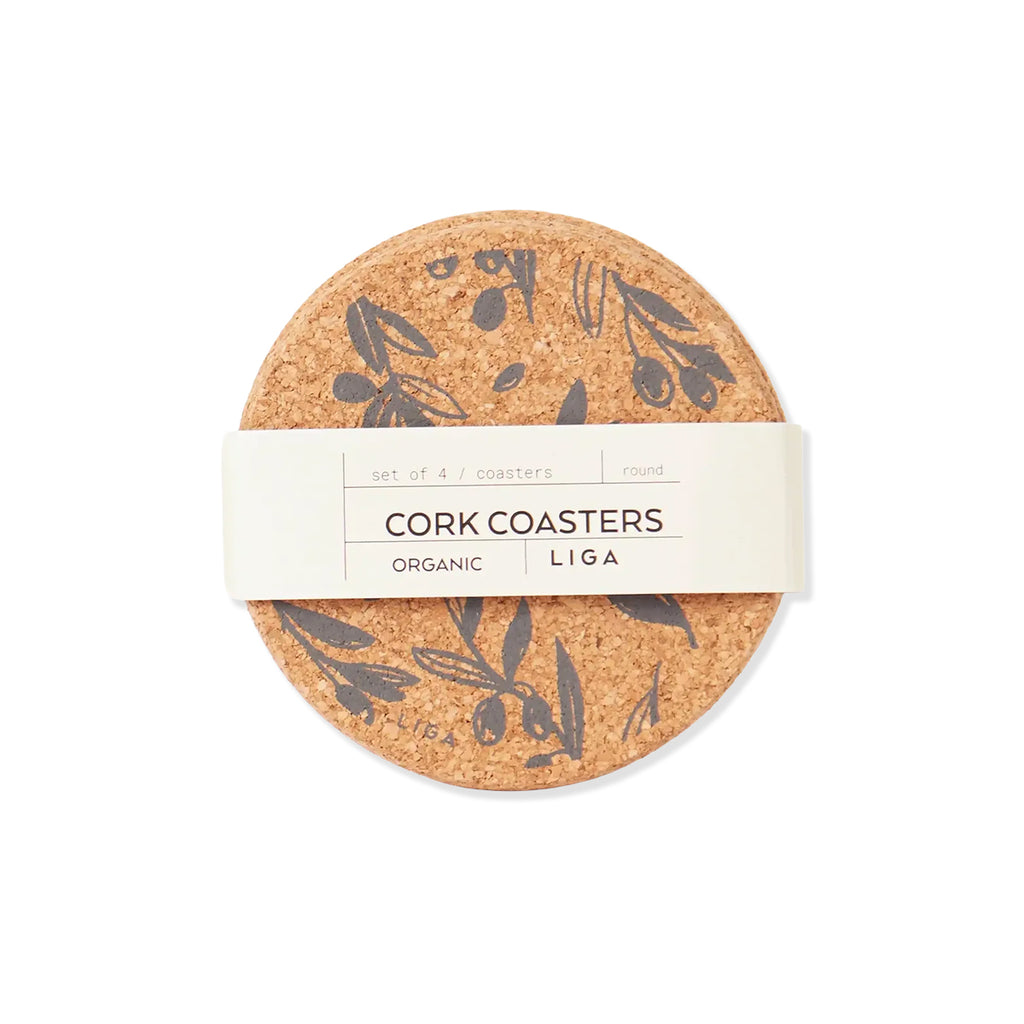 A set of four round cork coasters with a dark botanical olive branch pattern, wrapped in a white paper band labeled 'CORK COASTERS' and 'LIGA'.