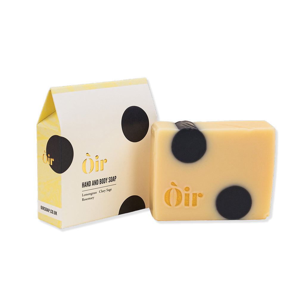 Yellow Oir soap bar with black dots and packaging on a white background