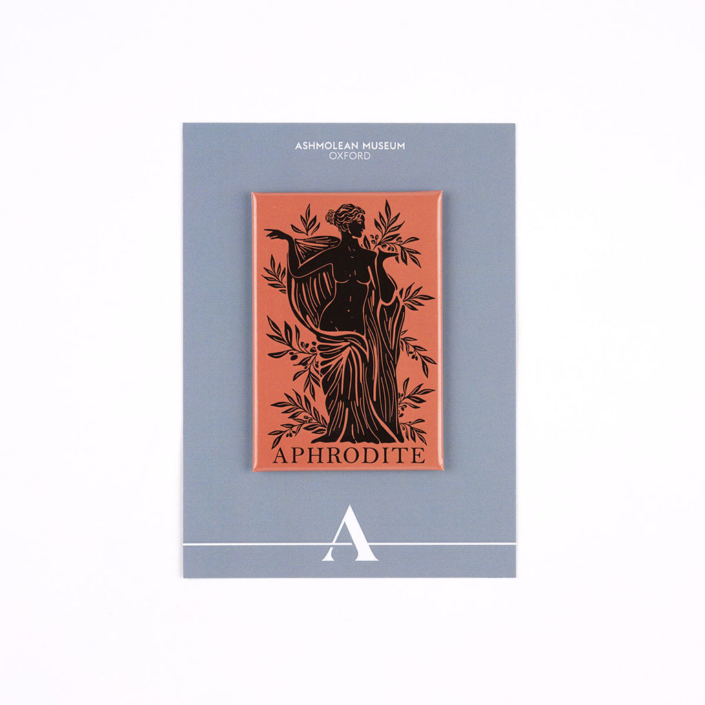 A rectangular pin featuring a black Art Nouveau illustration of a female figure on a terracotta background, mounted on a gray Ashmolean Museum Oxford display card.
