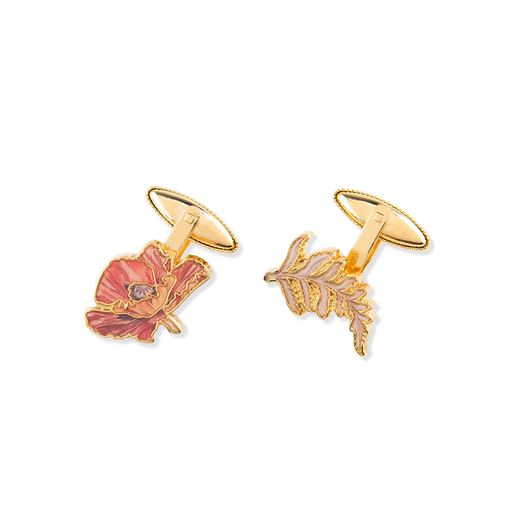 Gold cufflinks with floral and leaf designs on a white background
