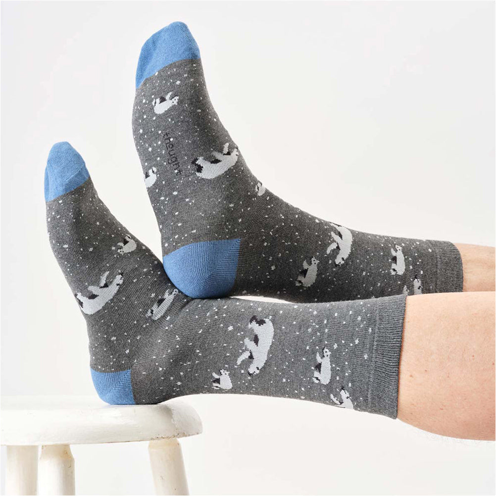 Gray socks with blue toes and heels worn by a person on a white background