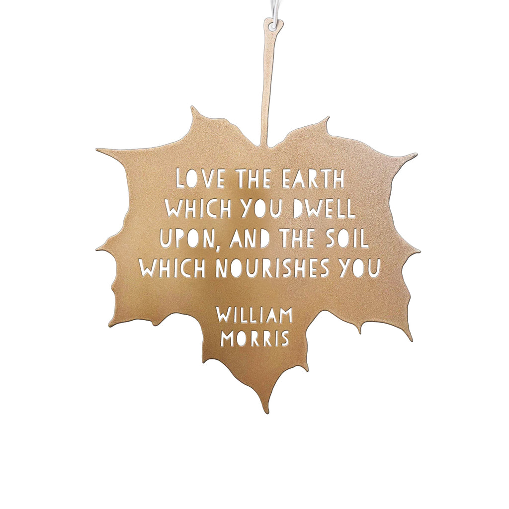 Decorative leaf-shaped sign with a quote by William Morris on a white background