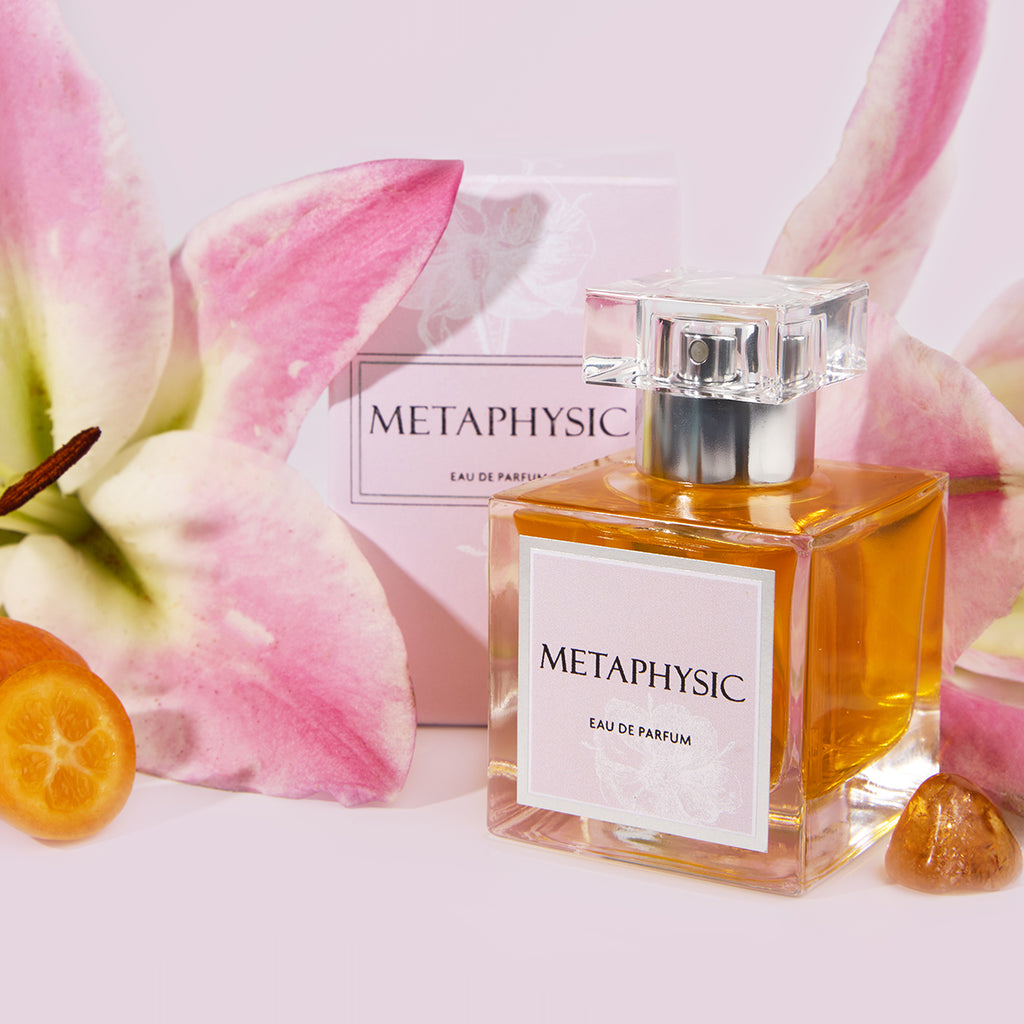 Metaphysic Eau de Parfum bottle with flowers and fruit on a light pink background