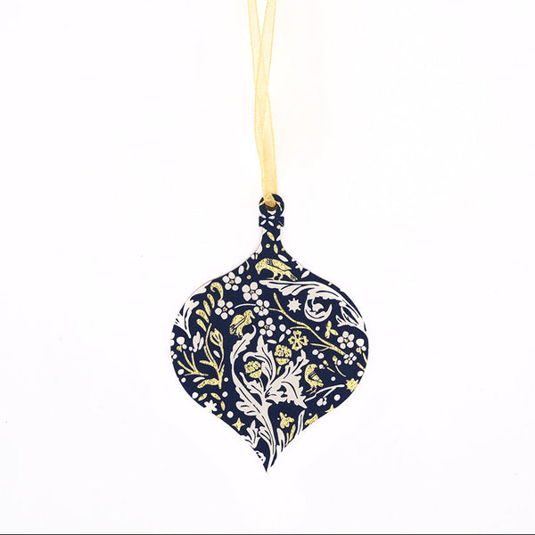 A hanging ornament shaped like a teardrop, featuring a navy blue body with a white and gold floral pattern, suspended by a gold ribbon against a plain white background.