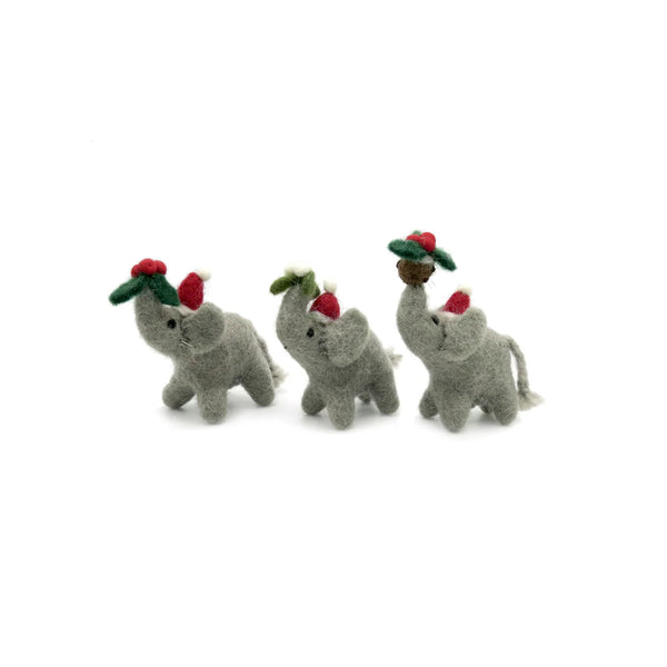 mini felt elephant Christmas decorations holding holly, mistletoe and Christmas pudding in their trunks on a white background. 