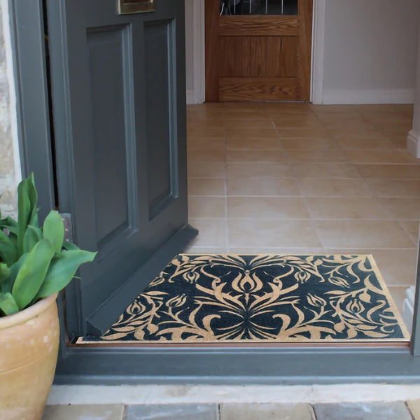 Blue May Morris flowers design floor mat inside doorway of home.
