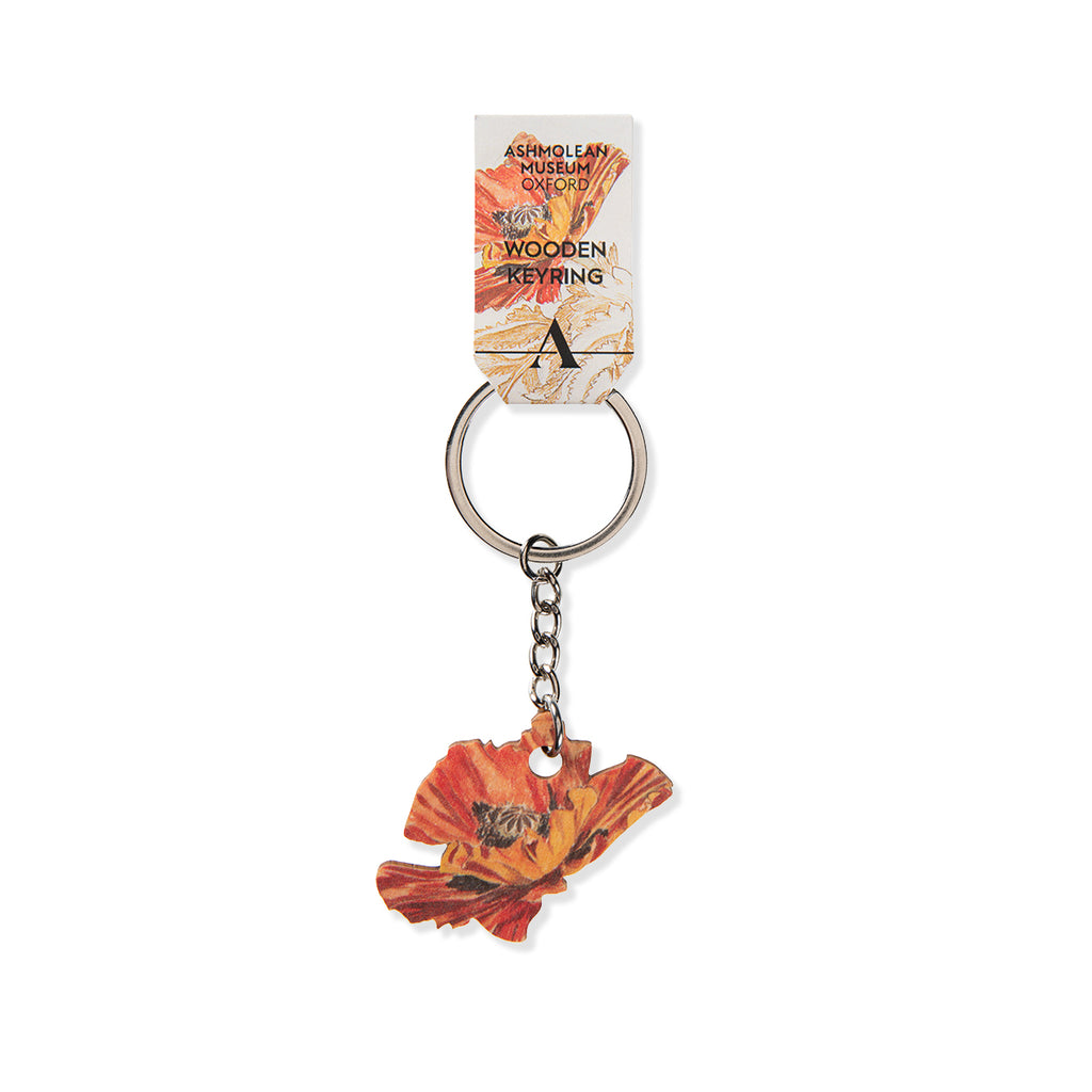 Wooden keyring shaped like red and black poppy flower with metal hardware and Ashmolean Museum branded tag on a white background