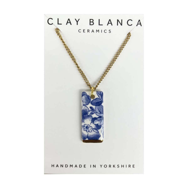 Necklace with a blue floral pendant on a Clay Blanca Ceramics card.