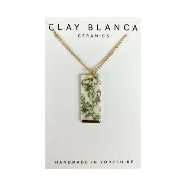 Necklace with a rectangular pendant featuring greenery on a Clay Blanca Ceramics card.