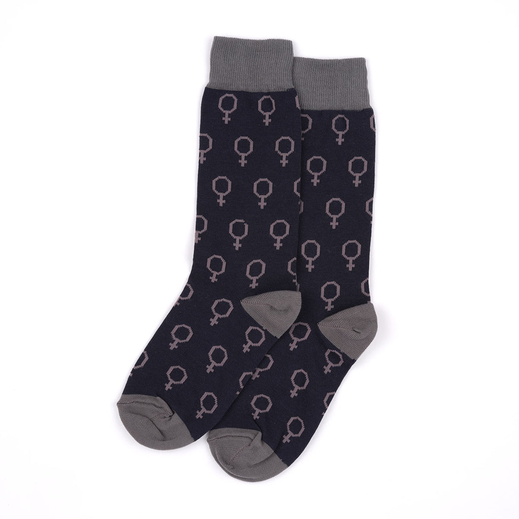 A pair of crew socks with a dark navy blue base featuring a repeating pattern of petrol green gender symbols, finished with solid grey cuffs, heels, and toes, displayed on a clean white background.