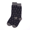 A pair of crew socks with a dark navy blue base featuring a repeating pattern of petrol green gender symbols, finished with solid grey cuffs, heels, and toes, displayed on a clean white background.