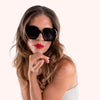 Woman wearing black sunglasses and red lipstick on a white background