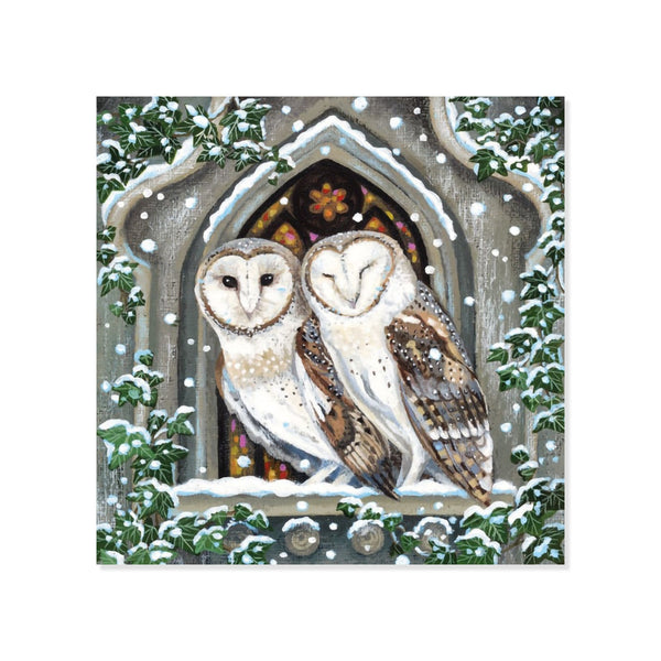 Artwork of two brown and white barn owls in stone church window sheltering from snowy weather on a white background.