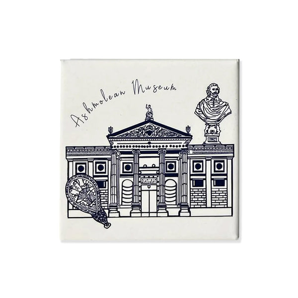 White fridge magnet with blue hand drawing of the Ashmolean Museum with cursive writing 'Ashmolean Museum' on a white background.