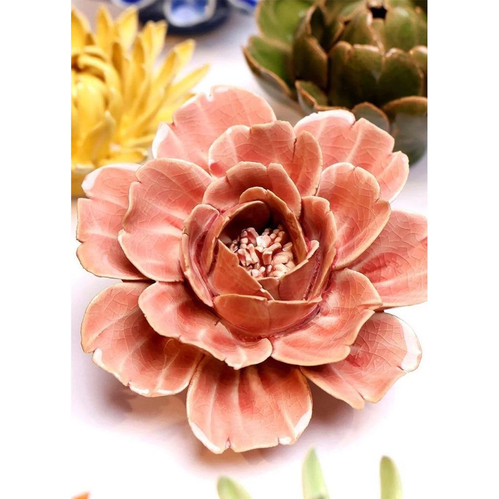 Close-up of a pink ceramic flower with other flowers in the background