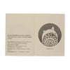 Open book with text and illustration of a carved wooden ornament on beige background