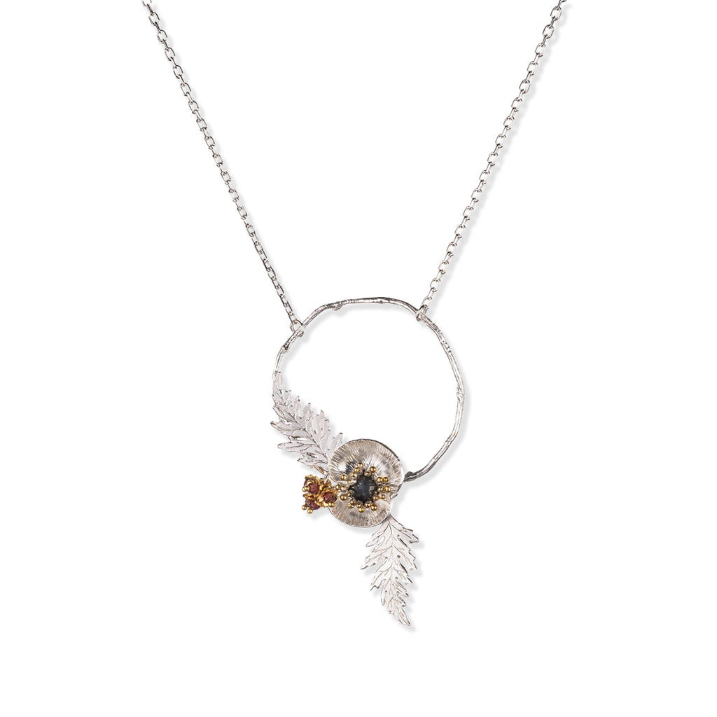 Necklace with a circular pendant featuring poppy leaves and a small gemstone beads on a white background