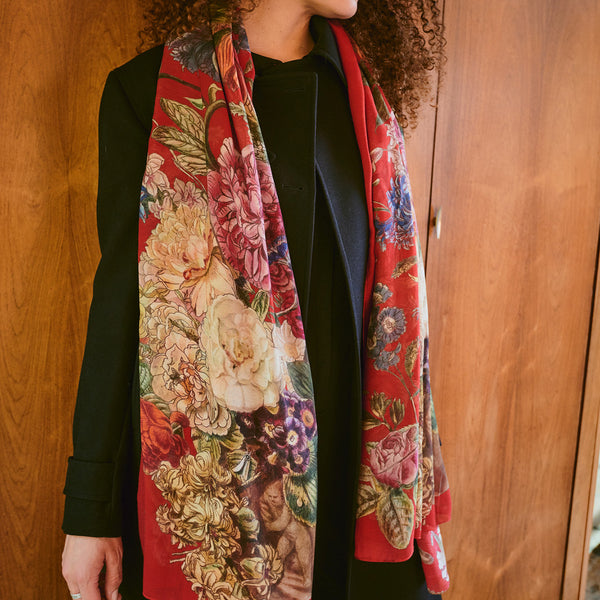 Person wearing a floral patterned scarf with a wooden background