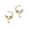 Gold hoop earrings with floral designs and pearl drops on a white background