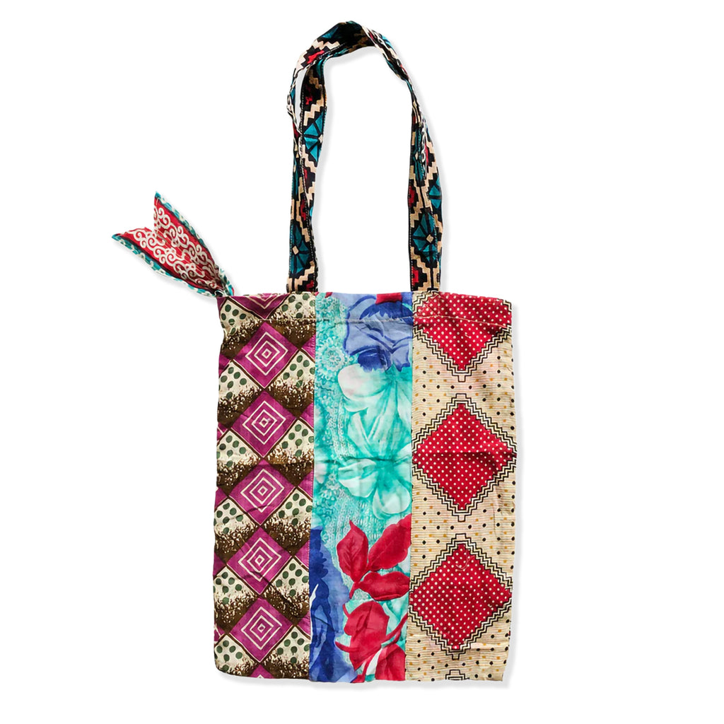 Colourful patchwork tote bag with patterned handle on a white background