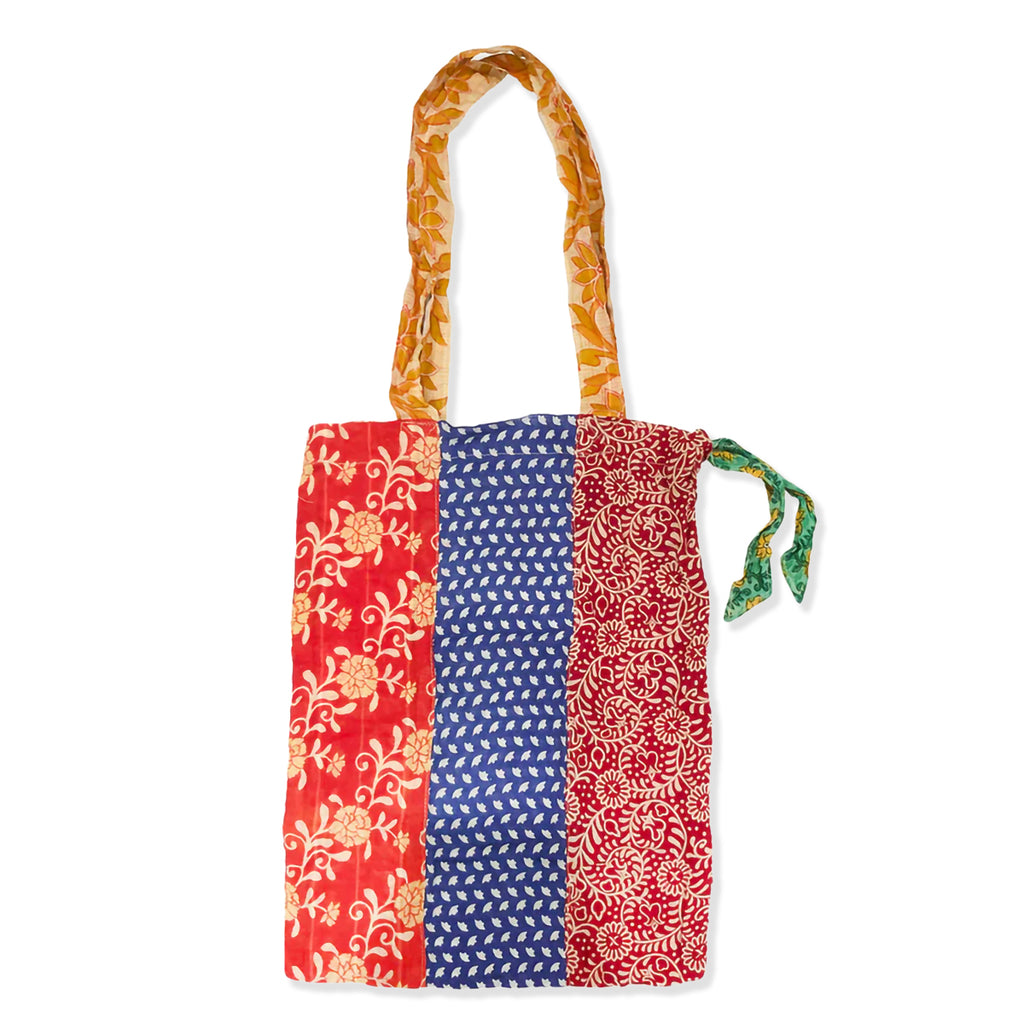 Colourful patchwork tote bag with patterned handle on a white background