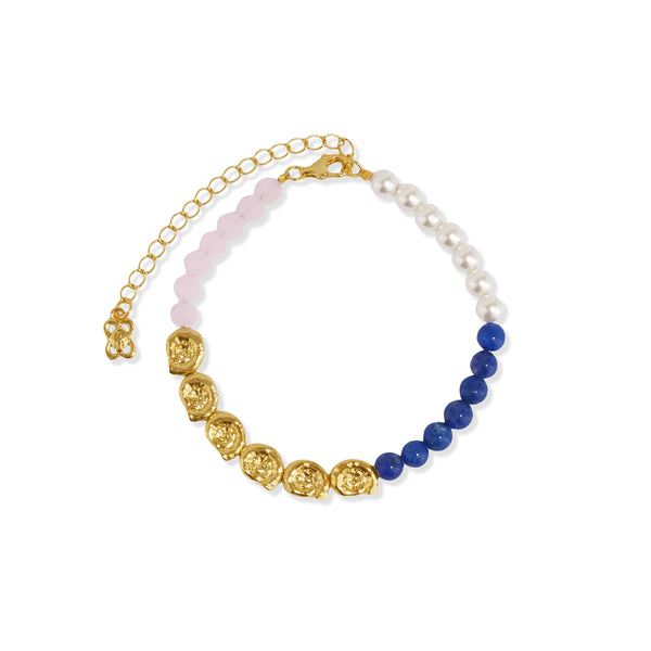 Gold tone bead bracelet with lapis lazuli, pink jade, faux pearl and golden shell beads on a white background.