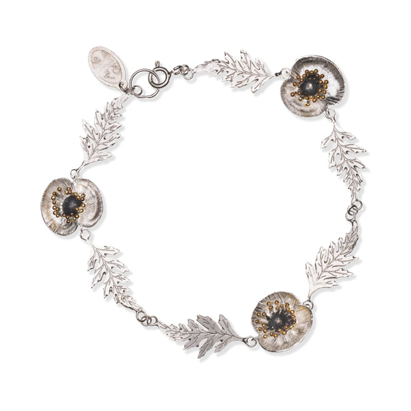 Silver bracelet with floral designs on a white background