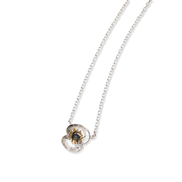 Silver poppy flower necklace with poppy flower pendant with oxidised silver and 22ct gold plated accents on a white background.