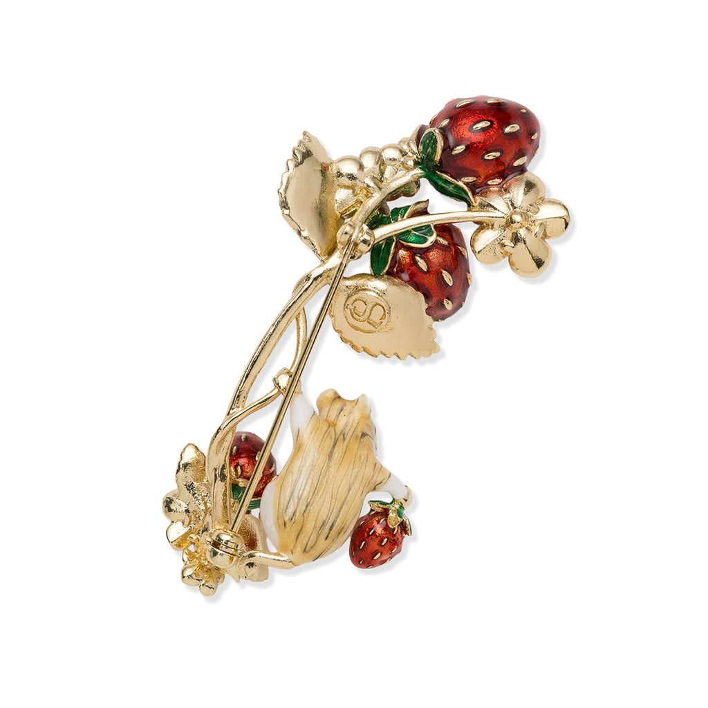 Gold brooch with red berries on a white background