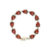 Bracelet with red enamel strawberries and gold clasp on a white background