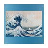Jigsaw puzzle with a design of a large wave and mountain, framed by a blue border.
