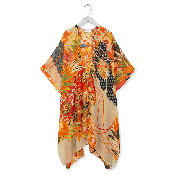 Orange and red throwover with cranes and eucalyptus pattern on a white background.