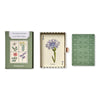 Open pack of wildflower playing cards with Jack of Clubs shown with cornflower illustrated artwork on card and green patterned backing on a white background. 
