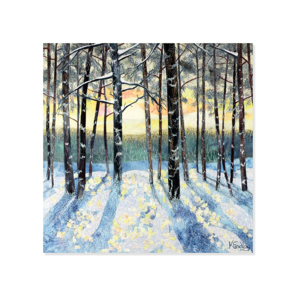 Winter forest scene with snow-covered trees and a sunset sky.