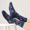 Navy blue socks with holly and robin pattern worn by a person on a white background
