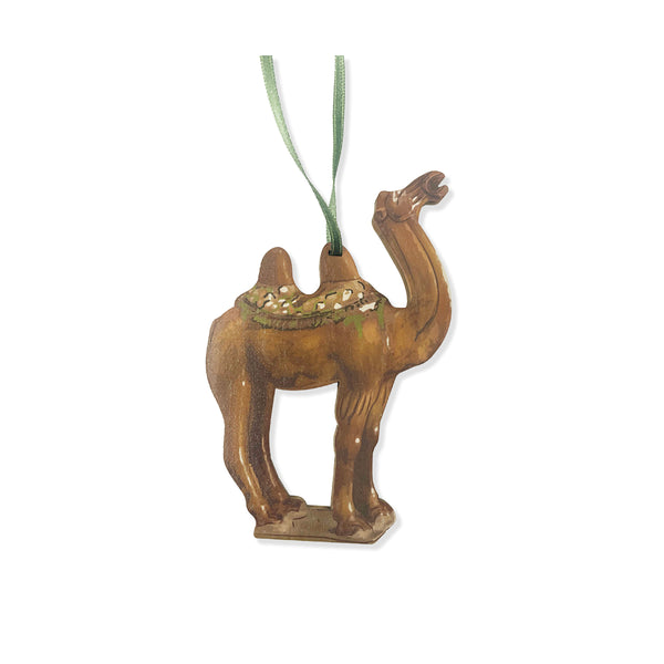 Wooden decoration of camel with green saddle on a white background.