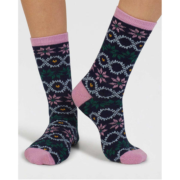 Pair of patterned fair isle socks with pink accents worn by a person on a white background