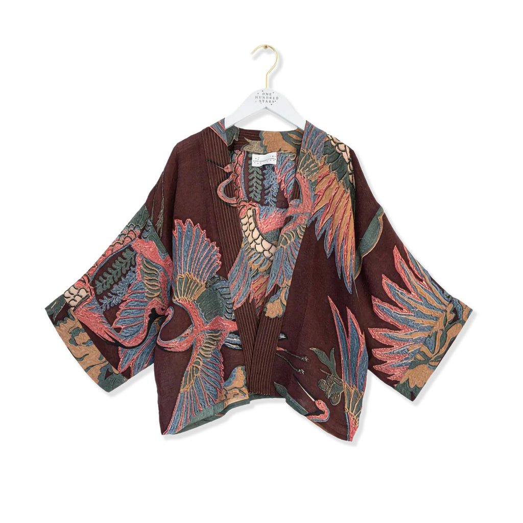 Patterned wool kimono in plum purple colour on a hanger against a white background