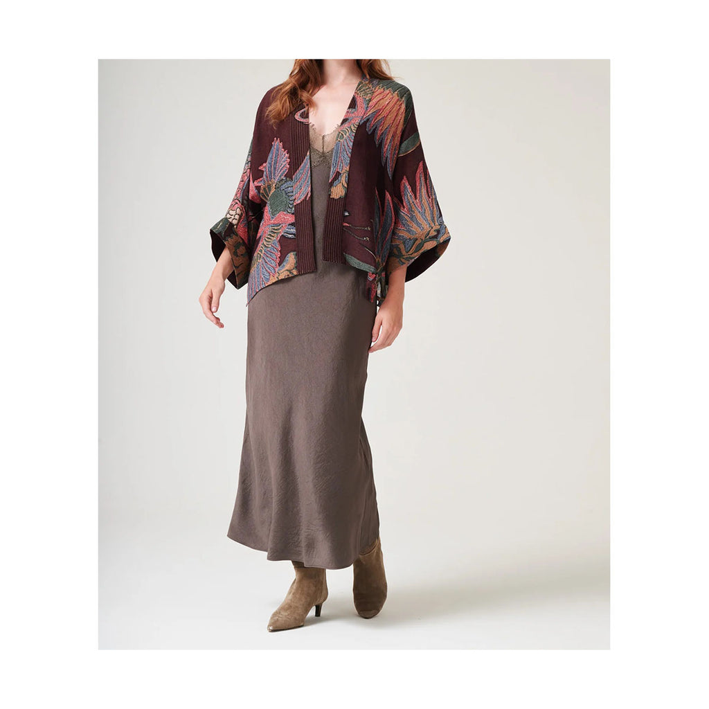 Woman wearing a patterned wool kimono and long skirt on a white background