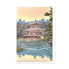 Traditional Japanese building reflected in water with trees in the background