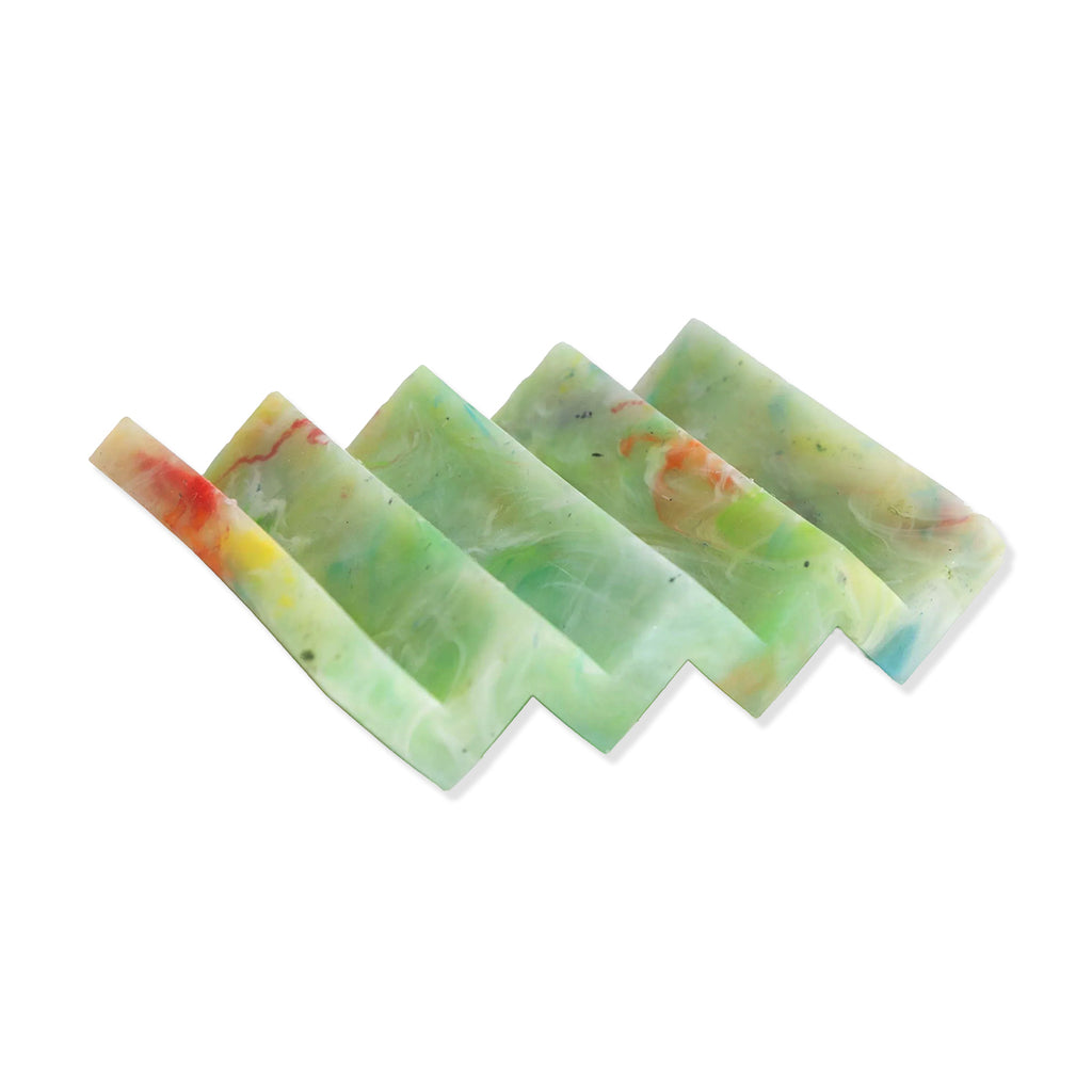 Green multicolour plastic soap dish in zig zag design on a white background