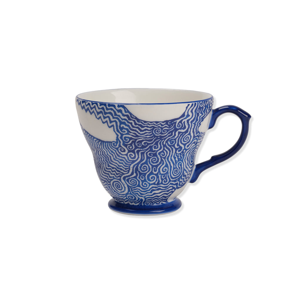Blue and white ceramic mug with wavy pattern on a white background
