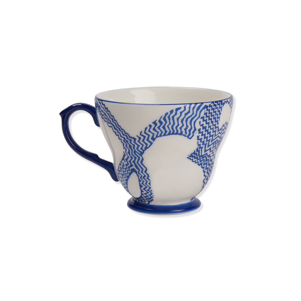 Blue and white ceramic mug with a pattern on a white background showing other side of cup 