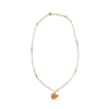 Gold tone necklace with amber beads and pendant shaped like tulip flower on a white background. 