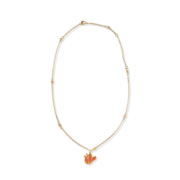 Gold tone necklace with amber beads and pendant shaped like tulip flower on a white background. 